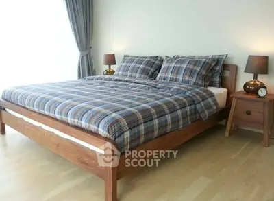 Cozy bedroom with wooden bed frame and plaid bedding, perfect for relaxation.