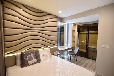 Modern bedroom with stylish wave-patterned wall and cozy workspace