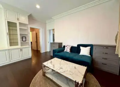 Spacious living room with elegant built-in cabinets and plush blue sofa, perfect for modern living.