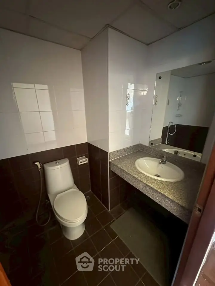 Modern bathroom with sleek design and functional layout, featuring a toilet and sink.