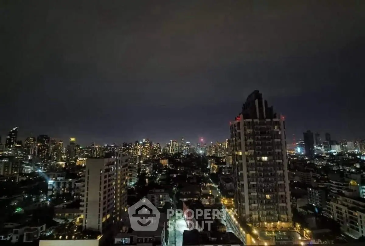 Stunning nighttime cityscape view from high-rise apartment balcony.