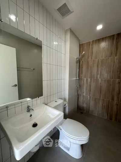 Modern bathroom with sleek fixtures and tiled walls in a contemporary apartment.