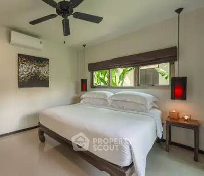 Luxurious bedroom with elegant decor and garden view, featuring a cozy bed and modern ceiling fan.