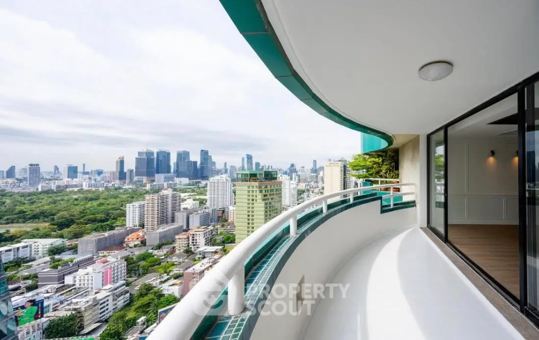 Stunning cityscape view from a spacious curved balcony in a high-rise apartment.