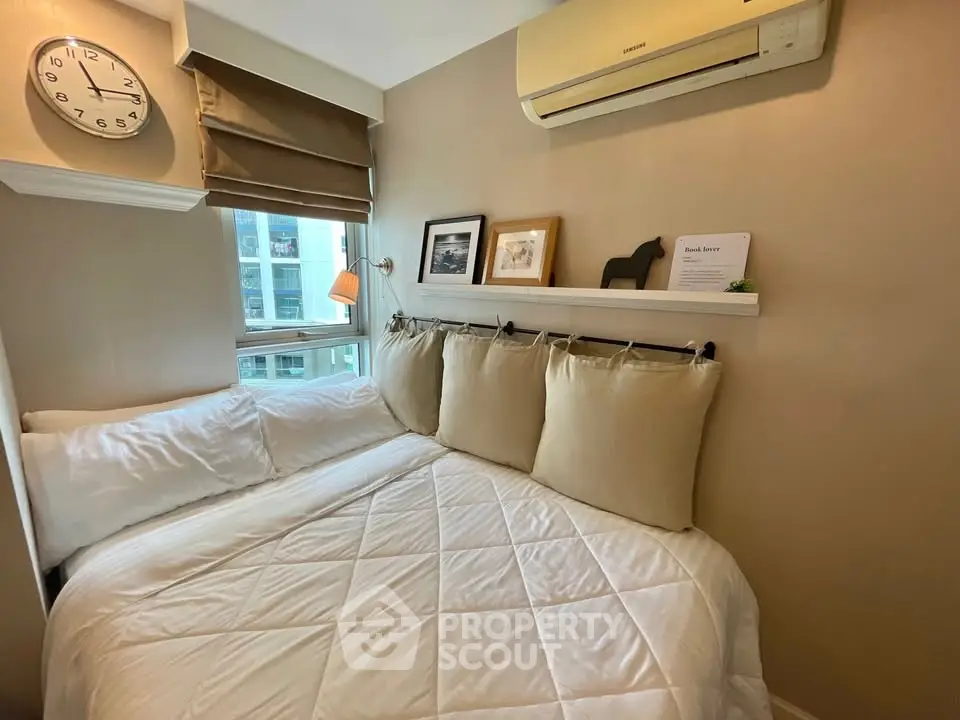 Cozy bedroom with modern decor and natural light in urban apartment.