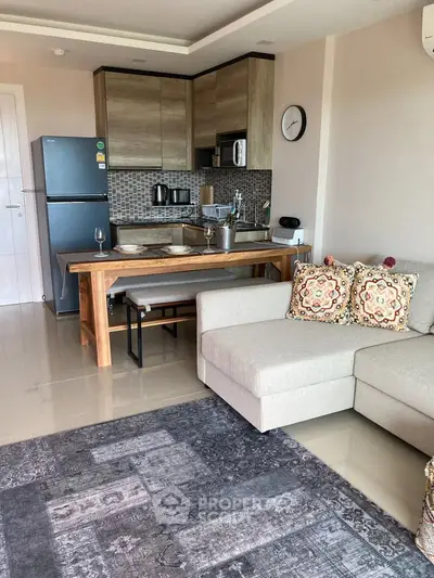 Modern open-layout kitchen and living room with stylish decor and cozy seating area.