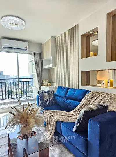 Stylish living room with blue sofa and city view balcony