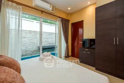 Cozy bedroom with pool view, featuring modern wardrobe and air conditioning for ultimate comfort.