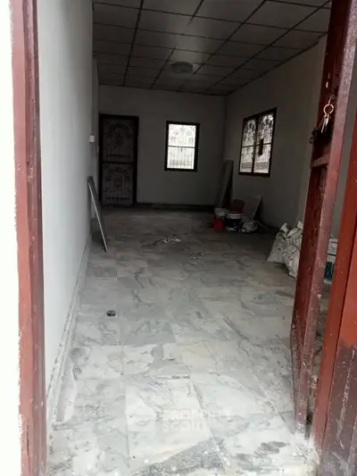 Spacious unfurnished room with marble flooring and large windows, ideal for customization.