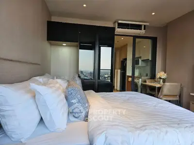 Luxurious bedroom with city view, modern furnishings, and cozy ambiance in high-rise apartment.