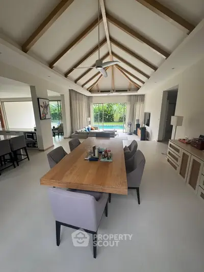 Spacious modern living room with high ceilings and pool view, perfect for luxury living.