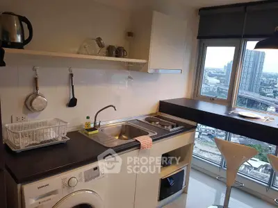 Modern kitchen with city view, featuring washing machine and sleek countertops.