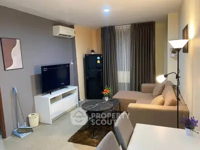 Modern living room with stylish decor, featuring a cozy sofa, flat-screen TV, and elegant lighting.