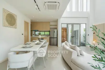 Modern open-plan living room and kitchen with elegant decor and natural light