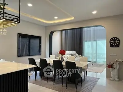 Modern dining area with elegant decor and open layout leading to a cozy living room.