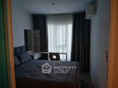 Cozy bedroom with modern furnishings and large window for natural light.