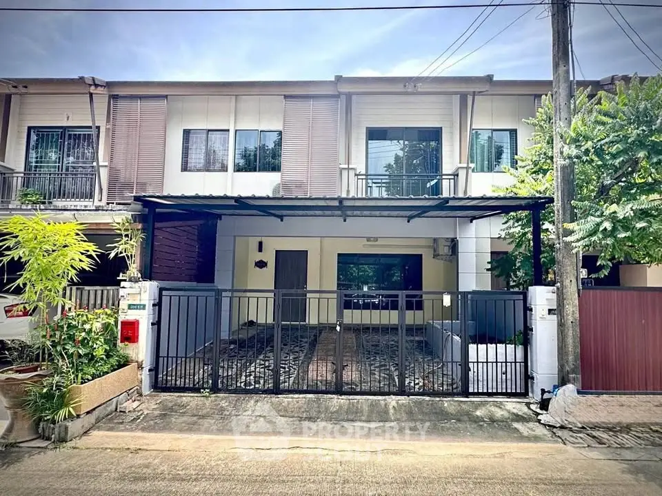 Charming townhouse with gated entrance and lush greenery in a serene neighborhood.
