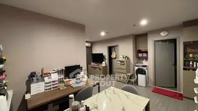 Modern living room with stylish decor and workspace in a cozy apartment setting.