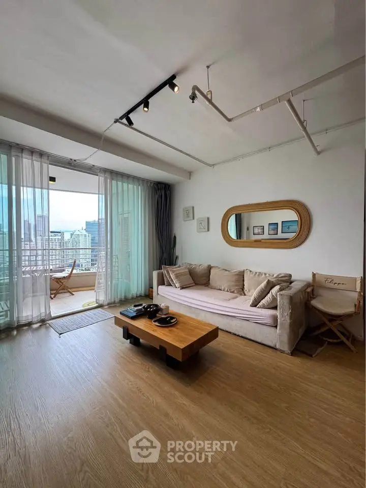 Spacious living room with modern decor and large windows offering city views.