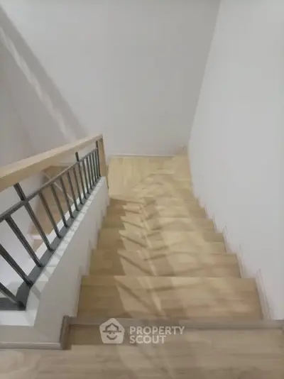 Modern wooden staircase with sleek metal railing in a contemporary home