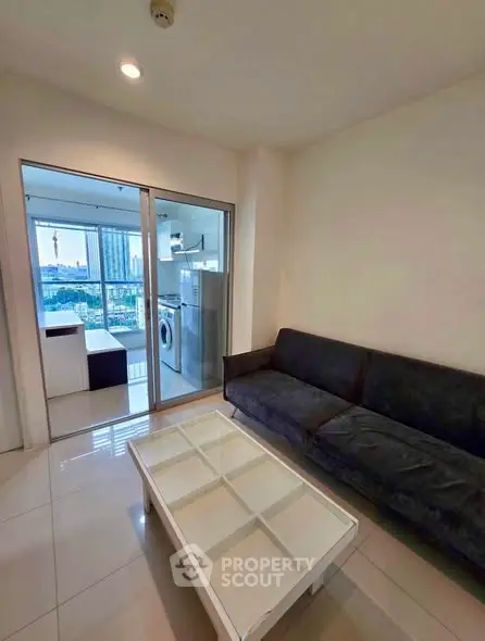 Modern living room with sleek furniture and city view from balcony, perfect for urban living.