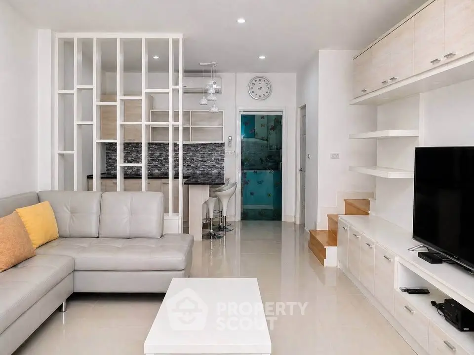 Modern living room with sleek furniture and open kitchen layout