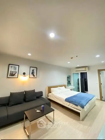 Modern bedroom with cozy bed, stylish sofa, and elegant decor in a bright apartment.