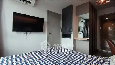 Modern bedroom with stylish decor and wall-mounted TV in a cozy apartment.