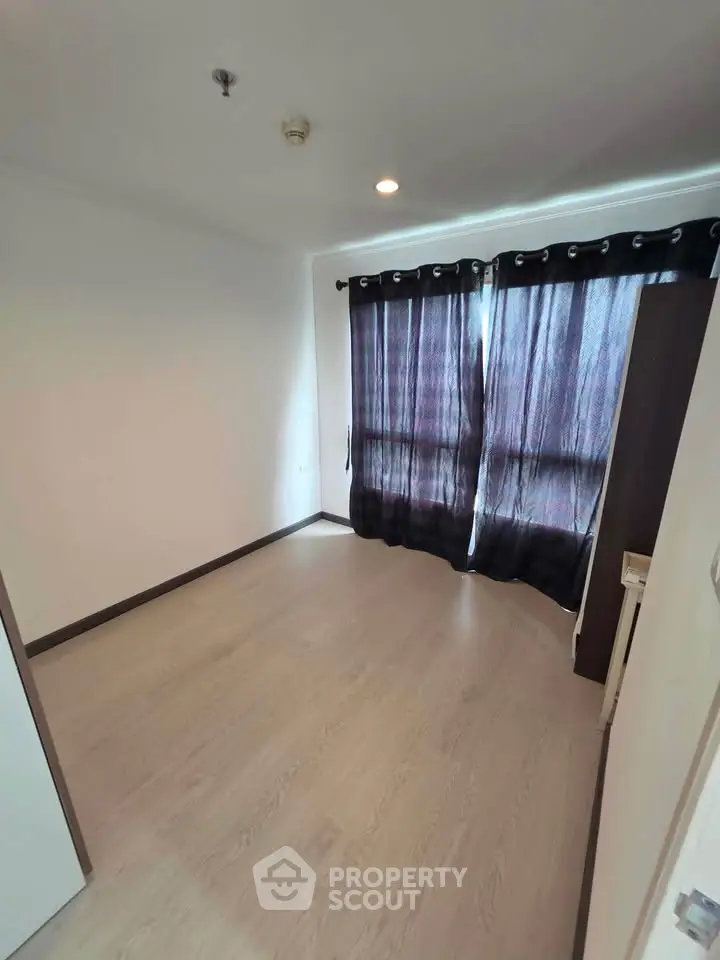 Spacious empty room with large windows and elegant curtains, perfect for customization.