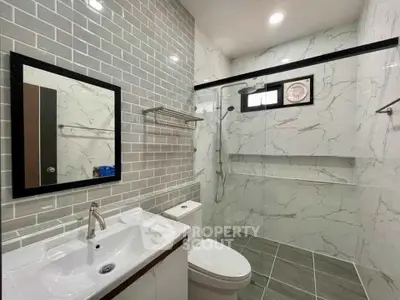 Modern bathroom with sleek tiles and glass shower enclosure