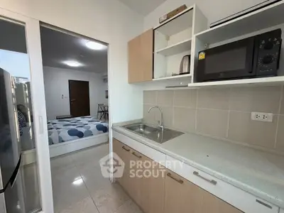 Modern kitchen with open layout and view into cozy bedroom