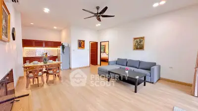 Spacious living room with modern decor and open layout, featuring a cozy dining area and stylish furniture.
