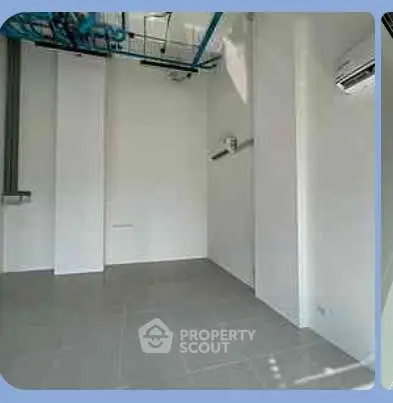 Spacious utility room with tiled flooring and modern air conditioning unit.