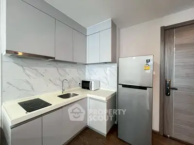 Modern kitchen with sleek cabinets, marble backsplash, and stainless steel appliances.