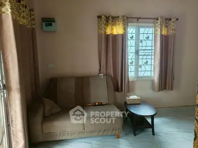 Cozy living room with a comfortable sofa and elegant curtains, perfect for relaxation.