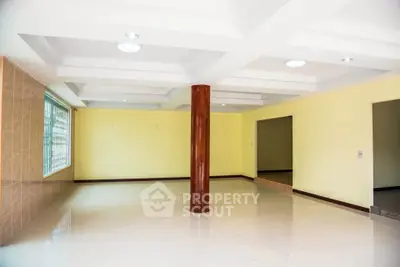 Spacious open-plan living area with modern ceiling design and large windows.