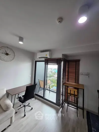 Modern living room with balcony view, featuring sleek furniture and abundant natural light.