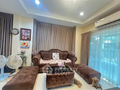 Cozy living room with plush brown furniture and large windows for natural light.