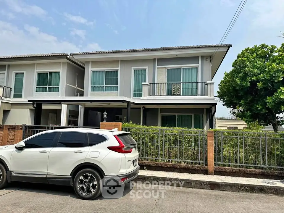 Modern two-story house with a sleek design and spacious driveway in a suburban neighborhood.
