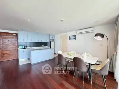 Spacious modern kitchen and dining area with sleek design and wooden flooring.