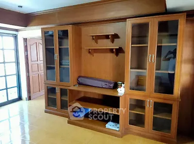 Spacious living room with elegant wooden cabinetry and ample natural light.