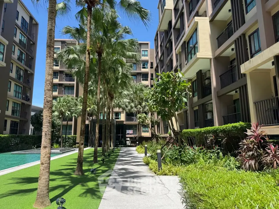 Modern condominium exterior with lush landscaping and poolside view