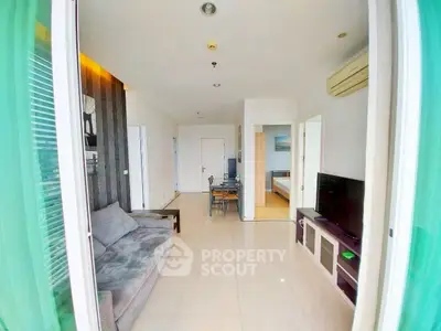Modern living room with sleek design and natural light, featuring a cozy sofa and entertainment unit.