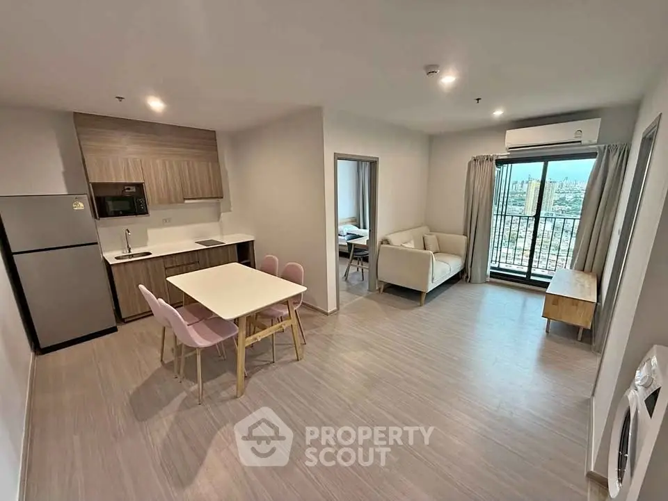 Modern open-plan living room with dining area and city view balcony