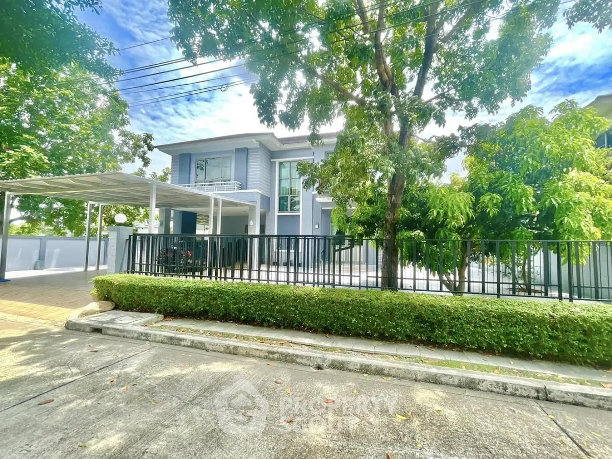 Stunning modern two-story house with lush greenery and spacious driveway in a serene neighborhood.