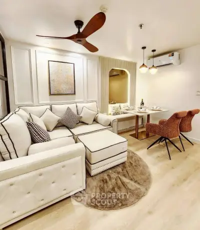 Elegant living room with modern decor and dining area, featuring stylish furniture and warm lighting.