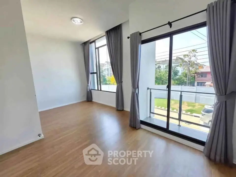 Spacious empty room with large windows and balcony access, perfect for customization.