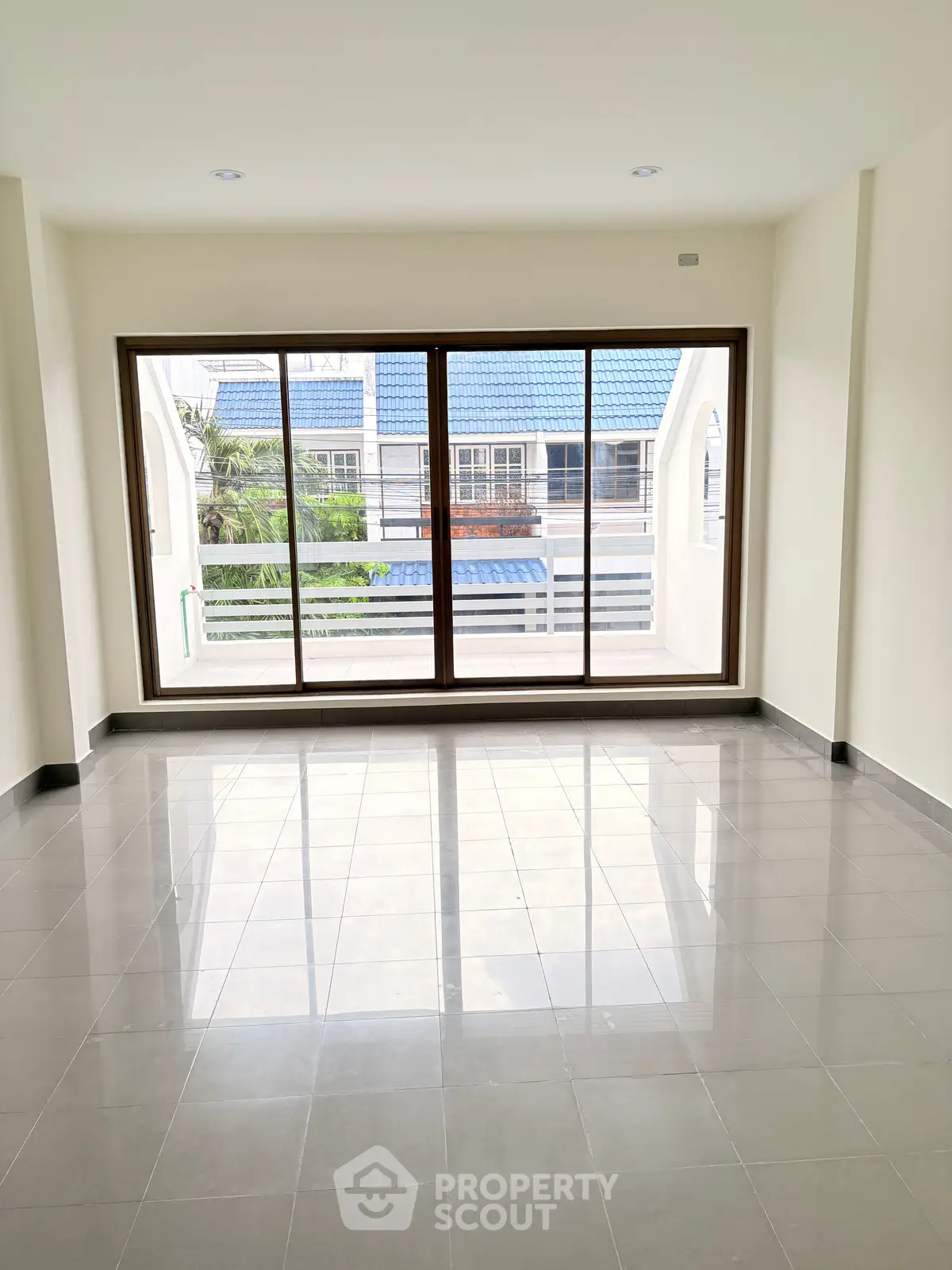 Spacious empty room with large windows and tiled flooring, perfect for customization.