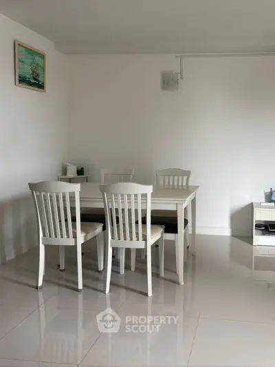 Minimalist dining area with white furniture and sleek tile flooring
