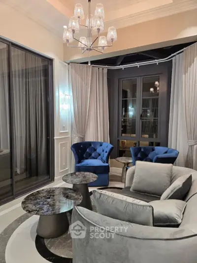 Luxurious living room with elegant blue chairs and modern chandelier